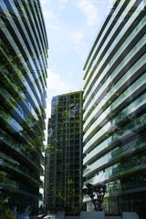 Fototapeta premium Modern buildings and lush trees against blue sky, double exposure. Low angle view