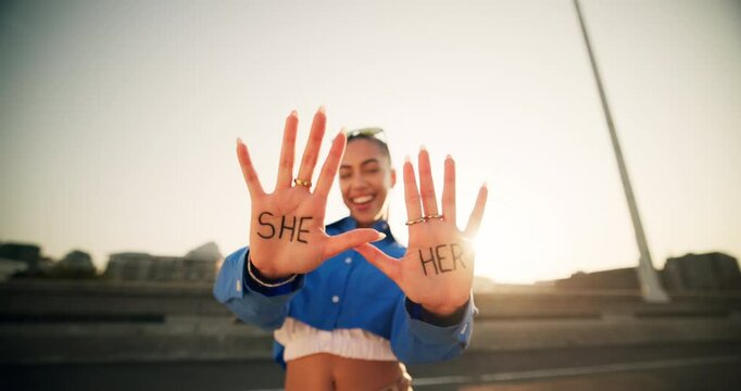 Happy, woman and hands with pronouns in city for gender identity, terminology and awareness. Female person, smile and face with word text on palm at sunset for she, her and preference information