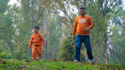 Cheerful Indian Father and son enjoying outside in the park, Fatherhood concept