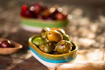 Olives, homemade marinated colorful olives with herbs and spices on rustic table, close up. Healthy Mediterranean vegan food, macro shot