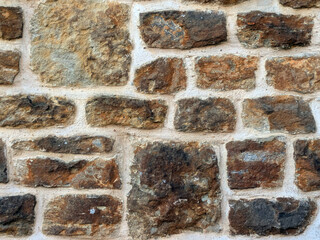 Old church wall with random handmade bricks and masonary old surface