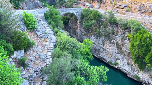 The historic Roman Oluk Bridge, or Eurymedon Bridge, in Koprulu Canyon. The ancient Roman bridge was built across the turquoise Kopruchai River in emerald green color.The National Park.Antalya,Turkey