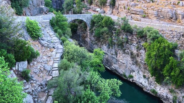 The historic Roman Oluk Bridge, or Eurymedon Bridge, in Koprulu Canyon. The ancient Roman bridge was built across the turquoise Kopruchai River in emerald green color.The National Park.Antalya,Turkey