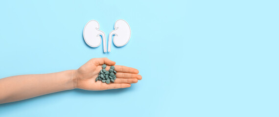 Woman with pills and paper kidneys on blue background