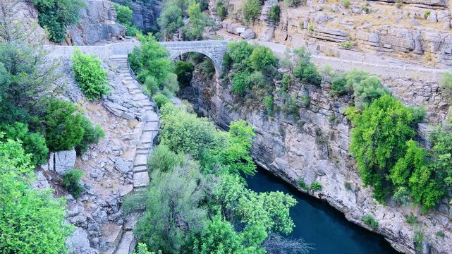 The historic Roman Oluk Bridge, or Eurymedon Bridge, in Koprulu Canyon. The ancient Roman bridge was built across the turquoise Kopruchai River in emerald green color.The National Park.Antalya,Turkey	