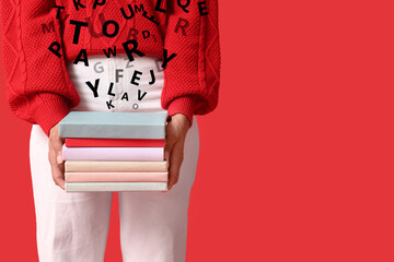 Woman with stack of books on red background, closeup