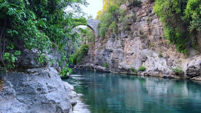The historic Roman Oluk Bridge, or Eurymedon Bridge, in Koprulu Canyon. The ancient Roman bridge was built across the turquoise Kopruchai River in emerald green color.The National Park.Antalya,Turkey
