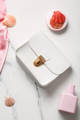 Stylish bag and perfume on white background
