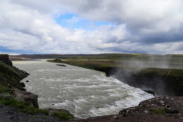 Gullfoss waterfall cascading into Hvítá river in Iceland under cloudy sky