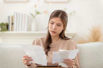 Asian woman feeling unhappy after looking at the bill feels stressed having financial problem, check finances, experiencing lack of money pay for loan, huge taxes, utility rates, get eviction notice