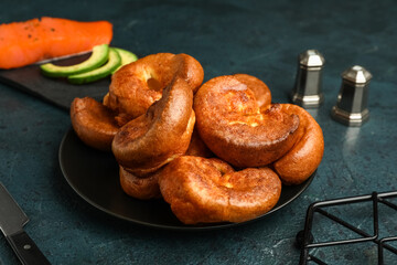 Plate with tasty Yorkshire pudding on blue background