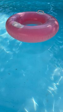 uma boia cor de rosa em cima da piscina