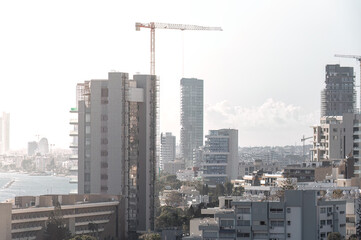 Fototapeta premium Construction crane building a modern skyscraper in Limassol city, Cyprus