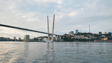 Fototapeta premium Scenic zolotoy rog bridge spanning golden waters, highlighting vladivostok's urban landscape against maritime backdrop