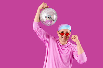 Cool mature man with disco ball on purple background
