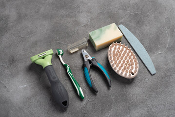 Pet care, hygiene and grooming tools on a grey concrete background