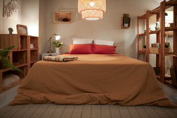 Interior of cozy bedroom with shelf units and glowing lamps at night