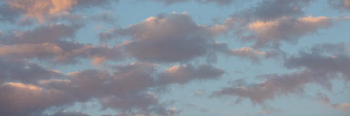 Obraz premium Beautiful sunset sky background with clouds. Scenic cloudscape. Wide panoramic background for design.