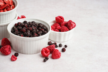 Bowls with tasty freeze-dried fruits on light background