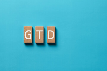 There is wood block with the word GTD. It is an abbreviation for Getting Things Done as...