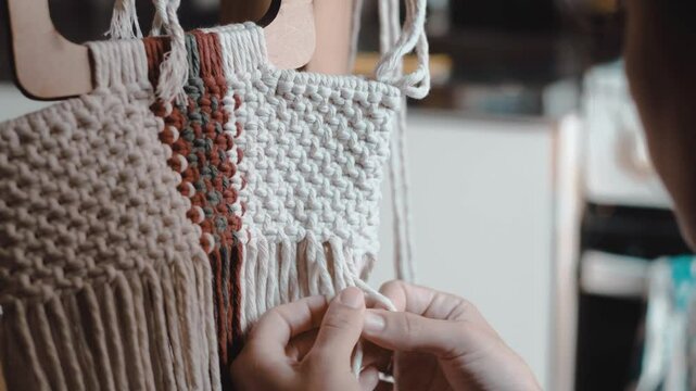 Video of a woman making macrame at home. Profile and close-up shots.