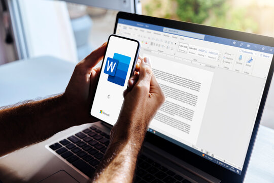 Man using a mobile phone displaying logo of Microsoft Word on the screen. A text processor developed by Microsoft company. ROSARIO, ARGENTINA - APRIL 3, 2025.