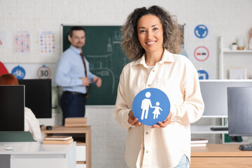 Mature woman with road sign at driving school