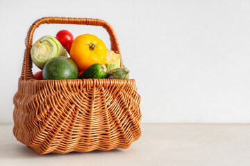 Wicker basket with different fresh vegetables on white background