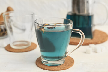 Cup of butterfly pea flower tea on table, closeup