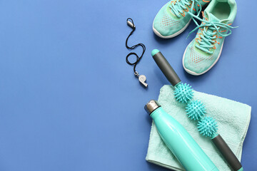 Sneakers, towel and sports equipment on blue background