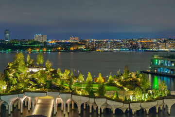 2021-10-28 THE NEW JERSEY SKYLINE AND LITTLE ISLAND FROM MANHATTAN AT NIGHT WITH A NICE GLOW IN HTE PARK AND BRIGHT BUILDINGS