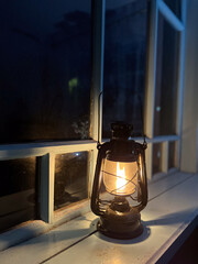A Vintage Lantern Effortlessly Illuminating a Cozy Window During a Peaceful Nighttime