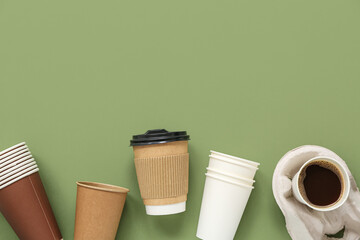 Different disposable cups of coffee on green background