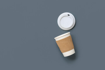 Disposable cup of coffee on grey background