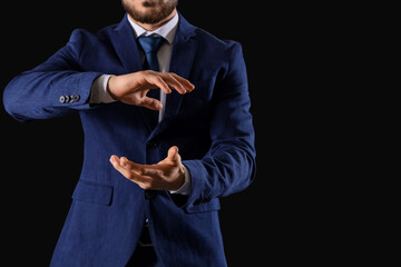 Businessman holding something on dark background, closeup. Goal concept