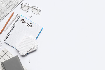 Empty to-do list with eyeglasses and stationery on white background