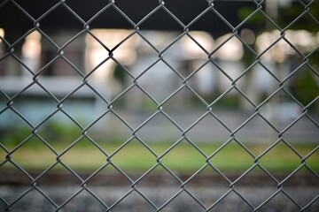 Fototapeta premium A quiet glimpse of a wire fence by the railway, bathed in shallow focus — a subtle and atmospheric background