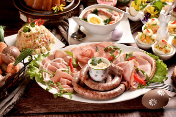 Easter breakfast with a plate of cold cuts, deviled eggs and vegetable salad on wooden table