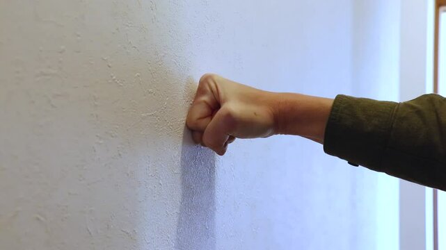 壁に突き当てられる拳