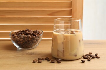 Coffee cream liqueur in glass and beans on wooden table