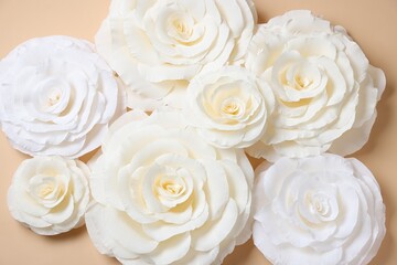Beautiful white paper flowers on beige background, flat lay