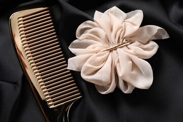 Beautiful hair clip and comb on black fabric, flat lay