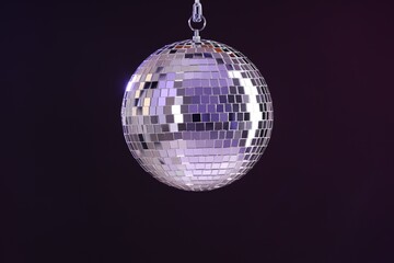 Obraz premium Shiny disco ball on dark purple background