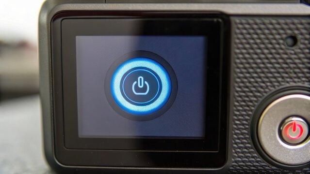 close up view of power button on device, featuring glowing blue ring around button. image conveys sense of technology and readiness for use