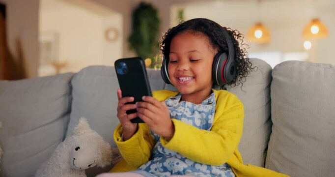 Girl, child and phone for music in home, watching video and listening to podcast for learning. Female person, kid and playing games in living room for mind development, happy song and streaming audio