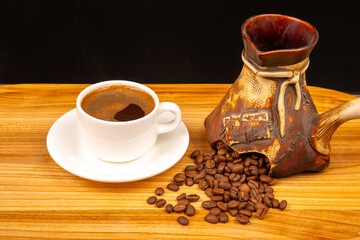 A rustic wooden tray holds a steaming cup of coffee in a white cup, a traditional cezve pot, and...