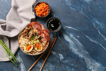 Bowl of ramen noodle soup with bacon and mushrooms on blue background