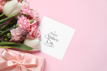 Bouquet of different beautiful flowers with greeting card and gift box on pink background. Mother's...
