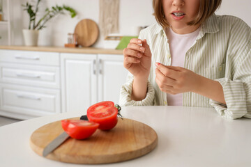 Young woman with cut finger in kitchen, closeup