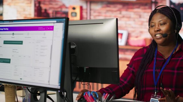 Call center worker tracking shipments at work, looking at computer screen, handling delivery delays. Customer center agent uses software to locate clients packages and provide status updates, camera A